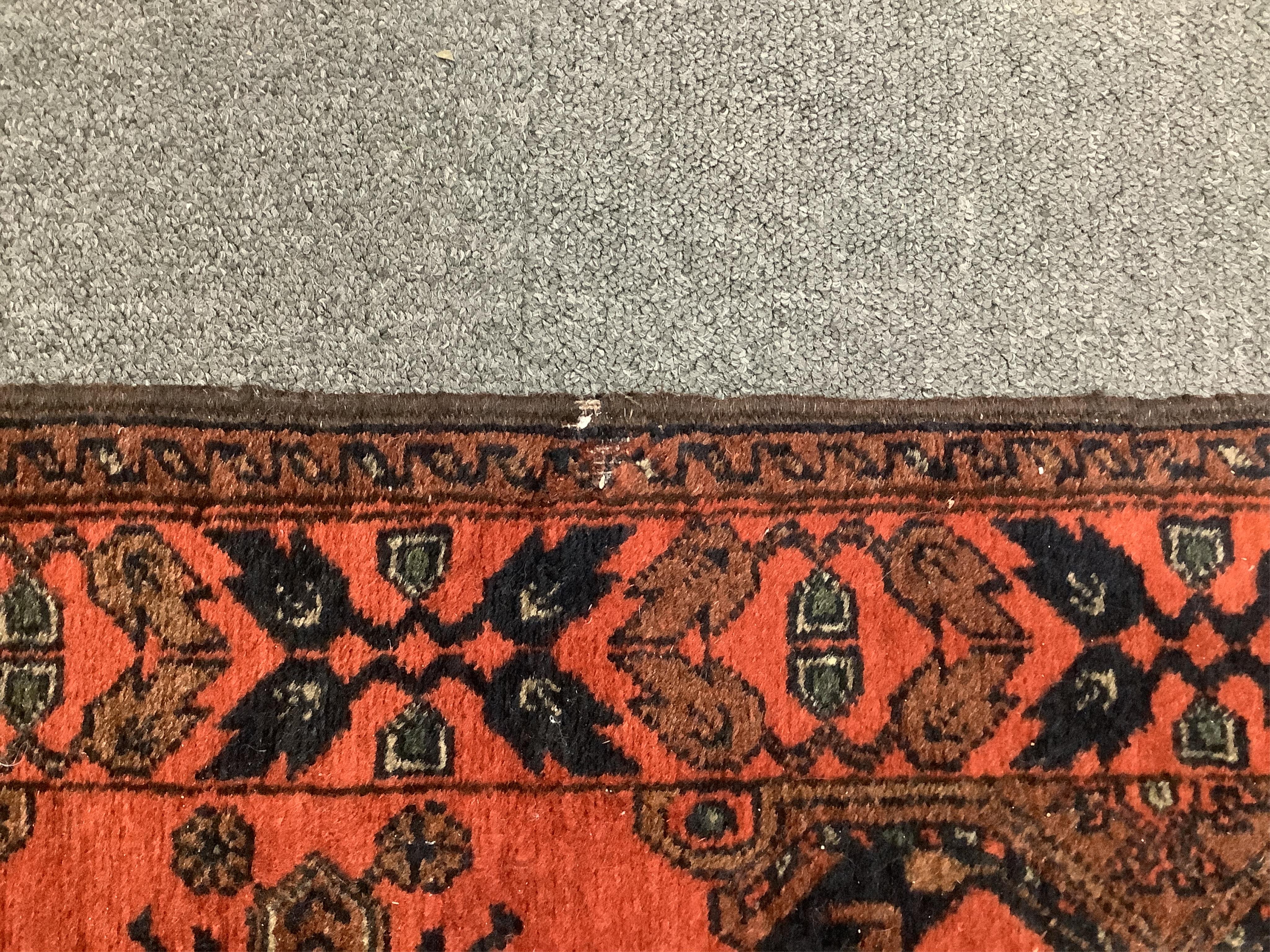 A large Pakistani Bokhara motif hand-knotted wool red ground runner, approx. 950 x 72cm. Condition - fair to good